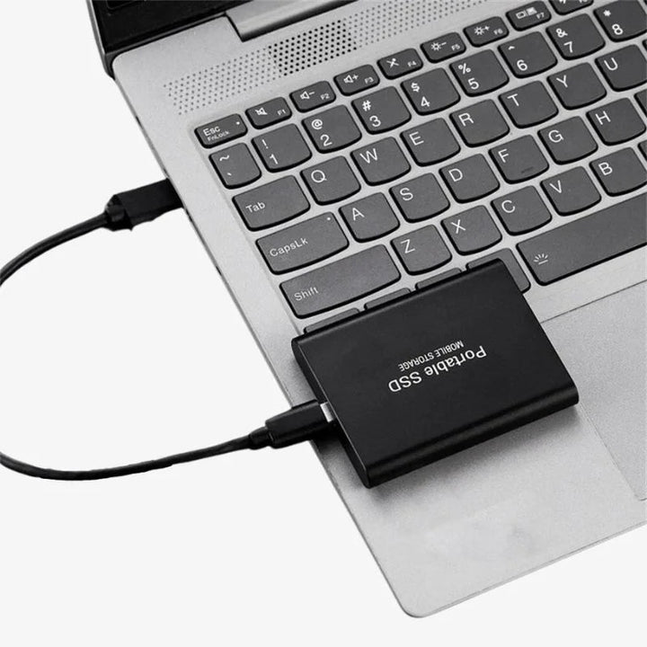 Liten bærbar SSD i hånd, fremhever kompakt design for enkel digital lagring.
