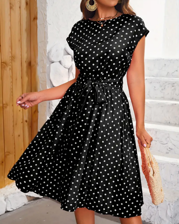 Nær detalj av stoffet på en prikkete polka dot kjole med elegant retro mønster og komfortabel stil.