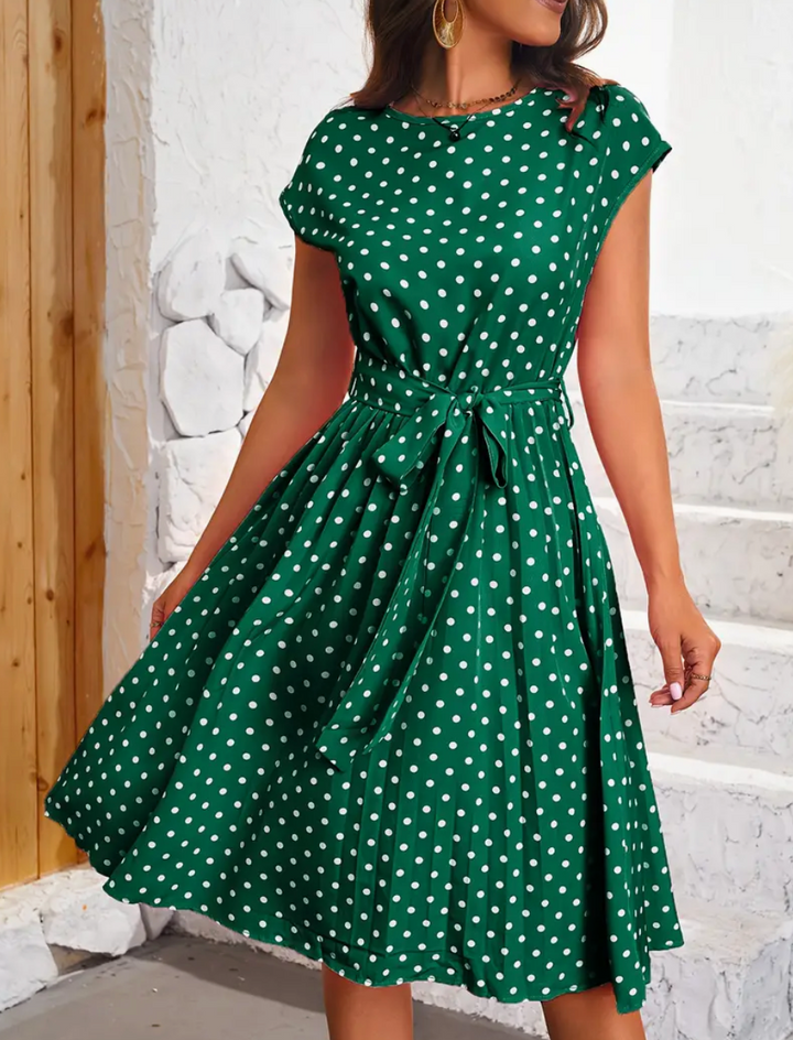 Modell i komfortabel og feminin retro polka dot kjole, perfekt for vår og sommer. Svingkjole med elegant fall.