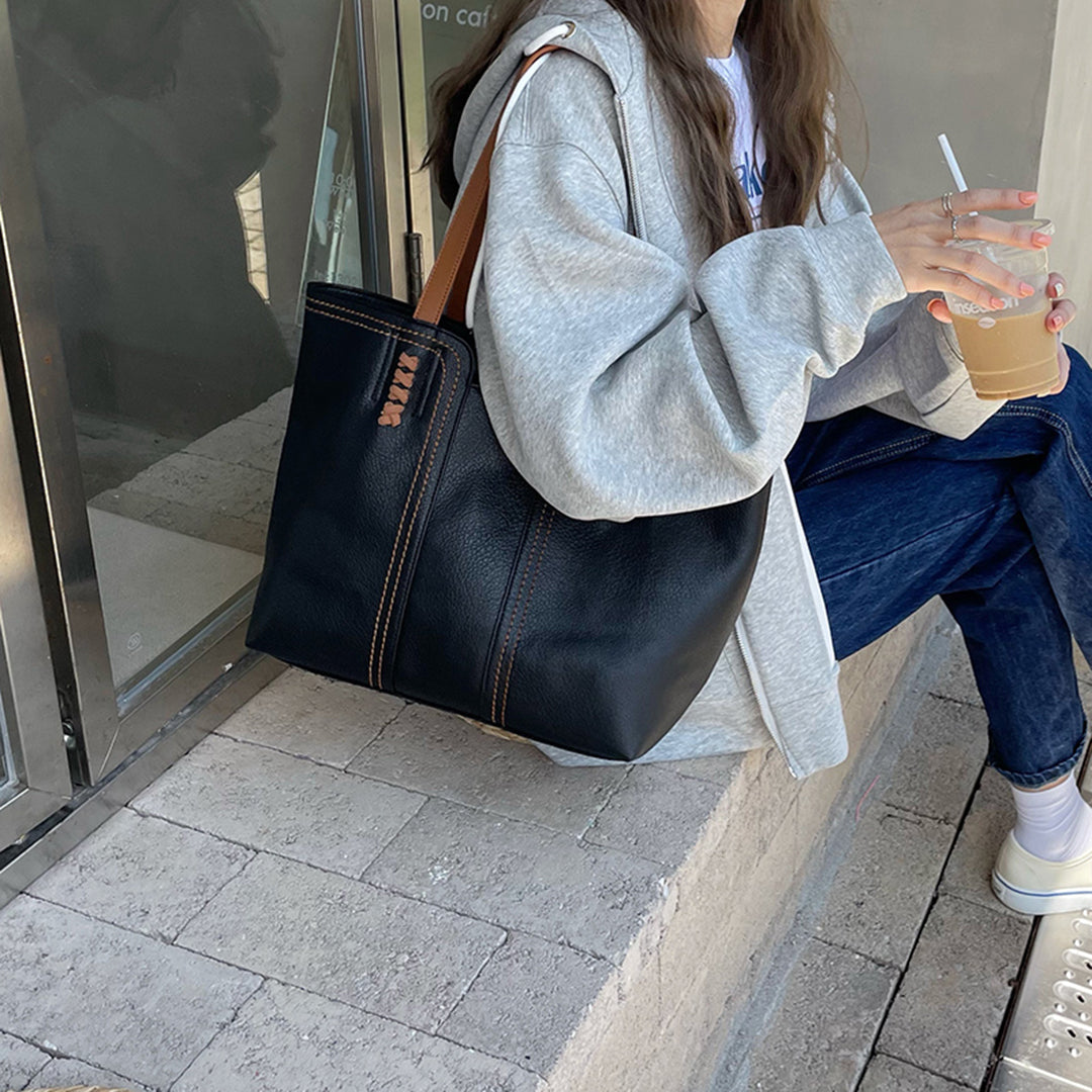 Stilren semsket skinnveske med unike kontrastfargede håndtak. En elegant dameveske og totebag for jobb.