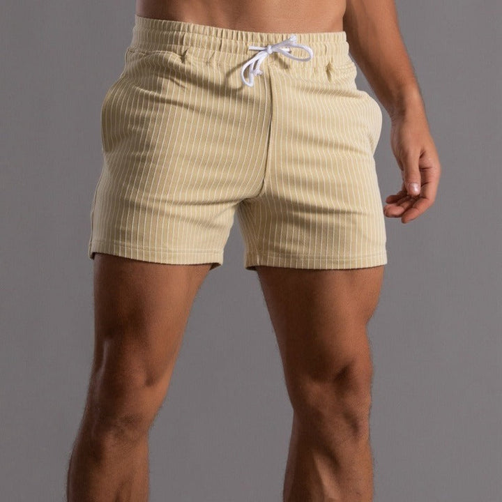 Detalj av elastisk midje på gule herreshorts, viser fleksibel og komfortabel passform.
