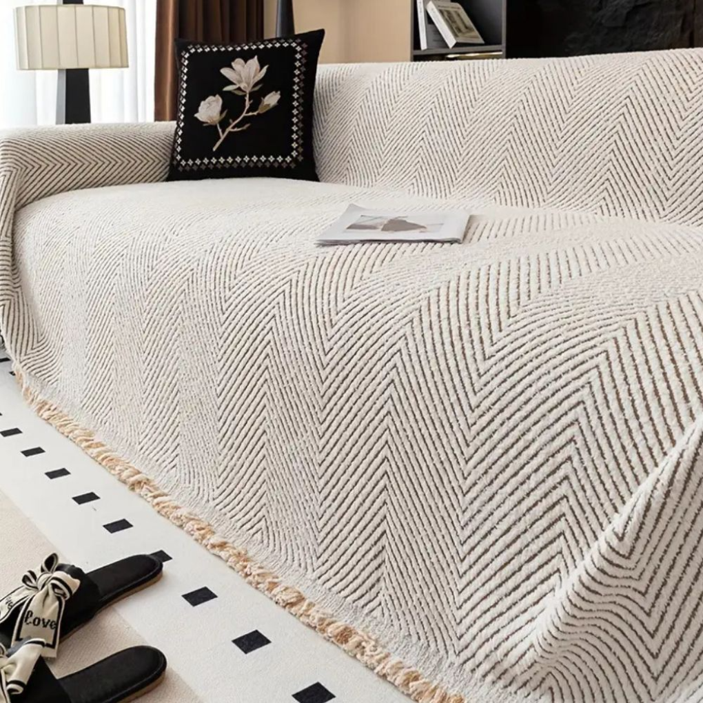 Stilrent vendbart sofatrekk med elegant fiskebensmønster. Perfekt for stuen og moderne interiør. Vaskbart tekstil.