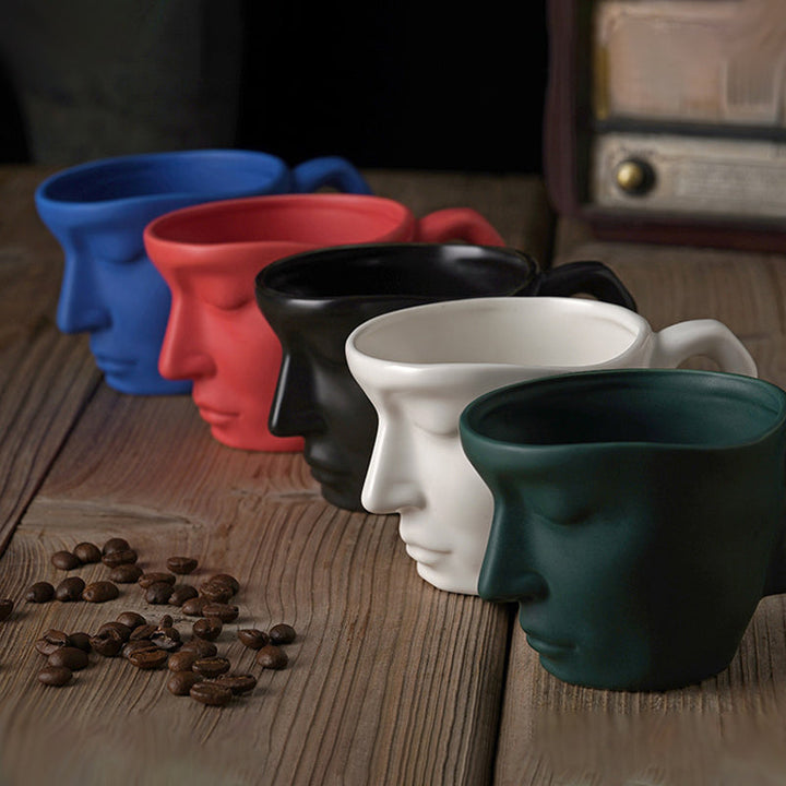Trendy keramisk kaffekopp med kreativt kyssende ansiktsmotiv. Legg stil til kjøkkenet ditt.