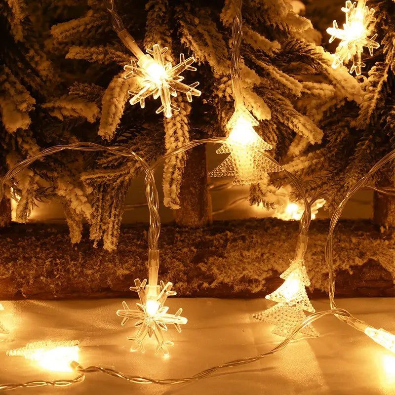 Varmgule LED snøfnugglys lyslenke henger i vinduet, skaper koselig julestemning.