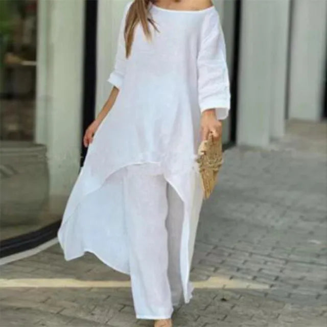 Modell i elegant og avslappet linsett for kvinner. Løs off-shoulder topp og vide bukser, perfekt vår/sommer.