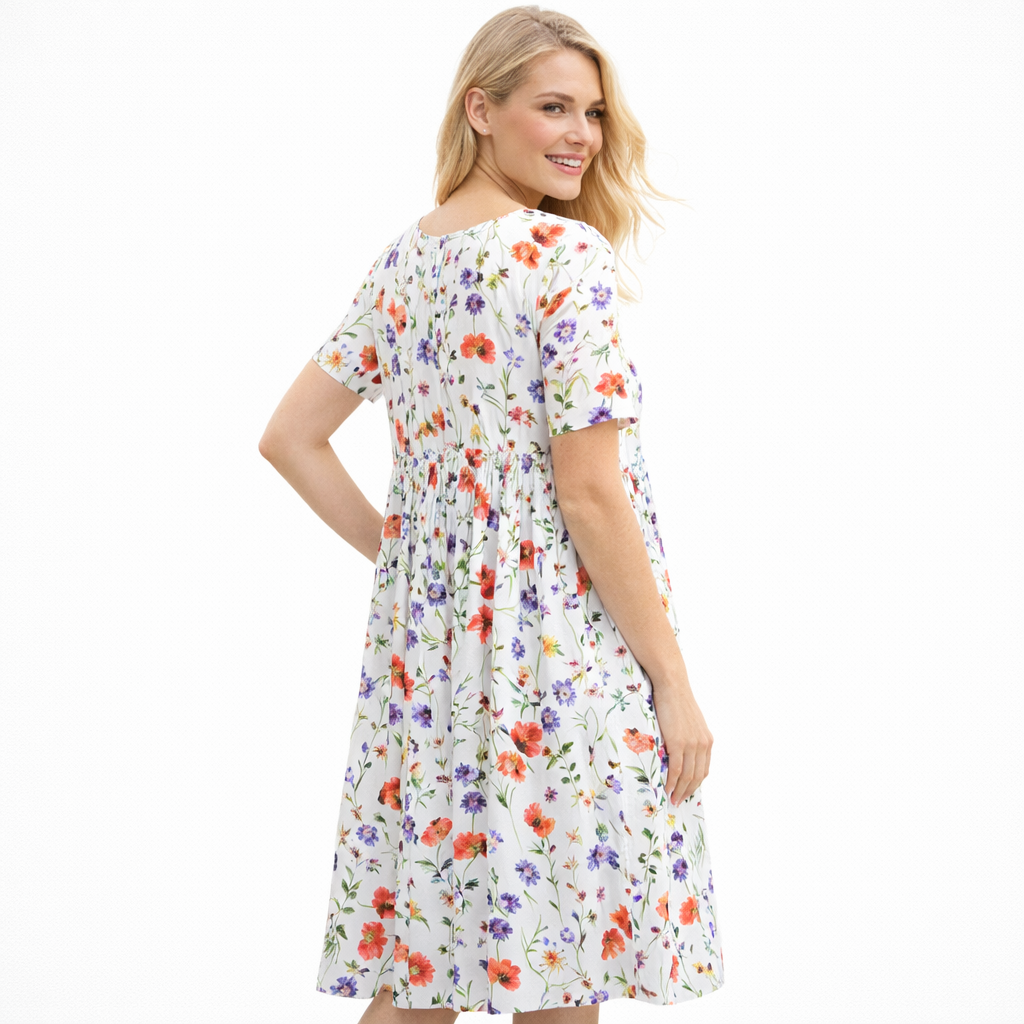 Frisk vårkjole med feminine blomster, vidt skjørt og korte ermer. Komfortabel damekjole med rund hals.