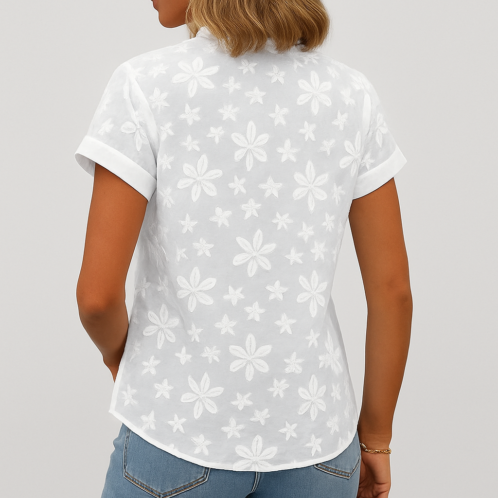 Feminin hvit kortermet topp med blomstret mønster og v-hals, en komfortabel og elegant sommerbluse.
