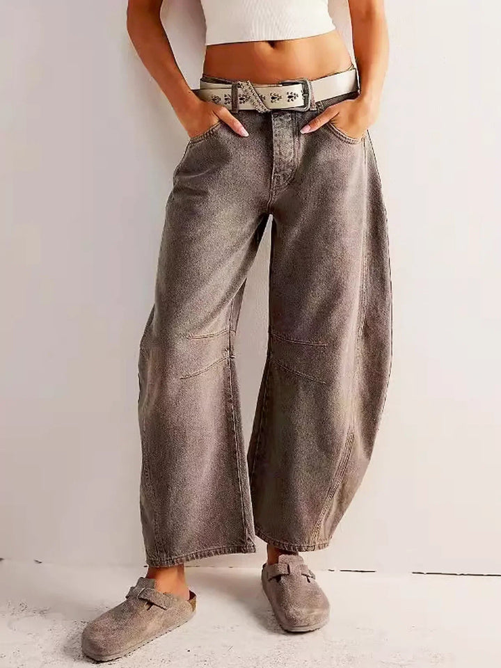 Detalj av mid-rise linning og knappestolpe på Dame Barrel Jeans. Kvalitetsdenim for komfortabel stil.