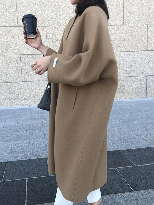 Varm beige ullkåpe for dame, lang og elegant. Utmerket yttertøy for kalde dager, stilren og tidløs.