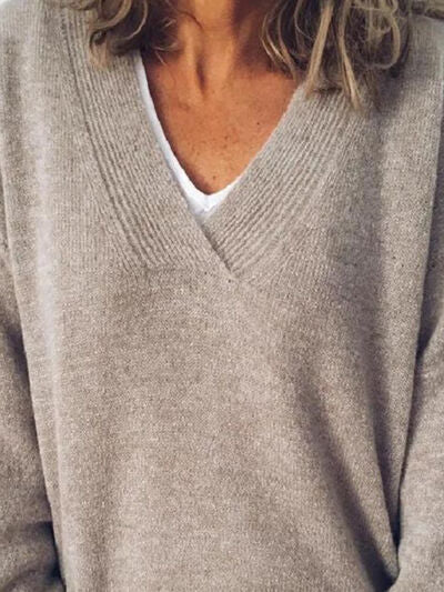 Allsidig dame strikkegenser med V-hals og droppede skuldre, perfekt for moderne lag-på-lag styling.