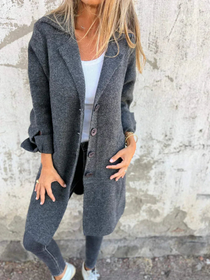 Nærbilde av stoffet på en komfortabel lang damefrakk. Allsidig allværsfrakk med elegant finish.