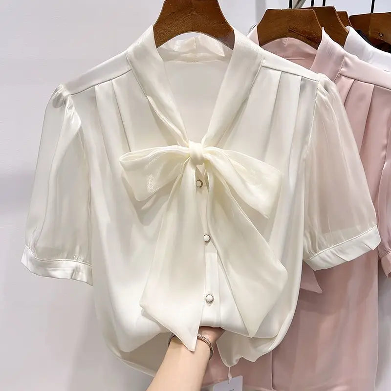 Kortermet sommerbluse med elegant snøring og dekorativ sløyfe. Stilren og feminin damebluse.