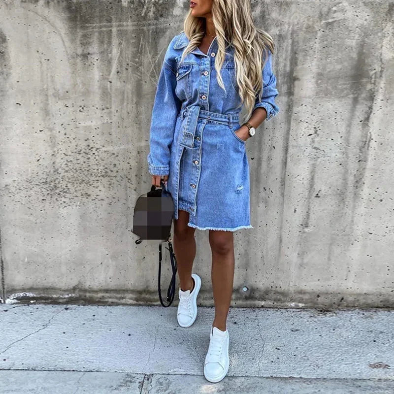Dame denimkjole, lang modell, med enkel knepping foran og praktiske sidelommer, casual og moderne.