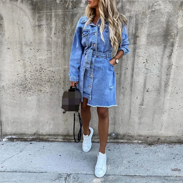 Dame denimkjole, lang modell, med enkel knepping foran og praktiske sidelommer, casual og moderne.