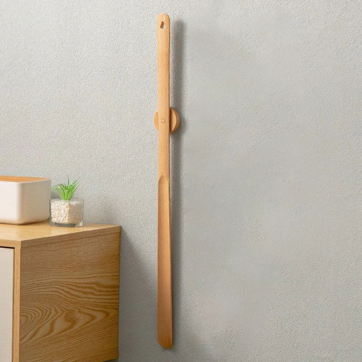 Bilde av 50 cm langt skohorn i tre, et ergonomisk hjelpemiddel for problemfri skopåsetting i hjemmet.
