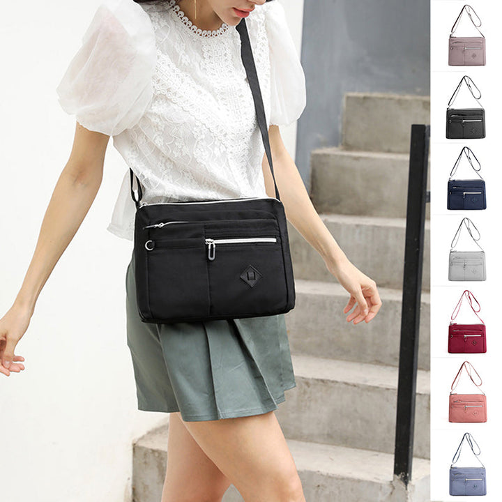 Nylon messenger bag for kvinner, med justerbar stropp og flere lommer.