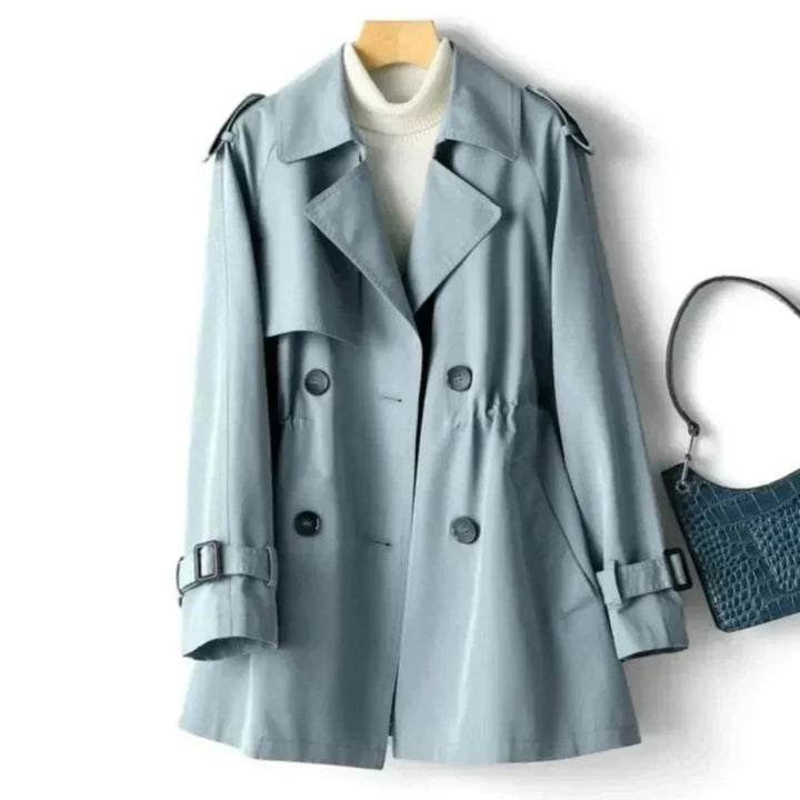 Tidløs dobbeltradet damekåpe. Trenchcoat med knapper, belte og lommer. Elegant yttertøy for alle anledninger.