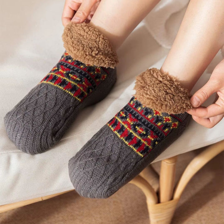 Svarte unisex hyttesokker med varmt fleecefôr og gummiert sklisikker såle for trygghet.