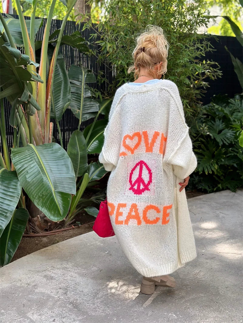 Oversized damecardigan i mykt stoff med unikt "Love & Peace" mønster. Trendy og avslappet lang genser.