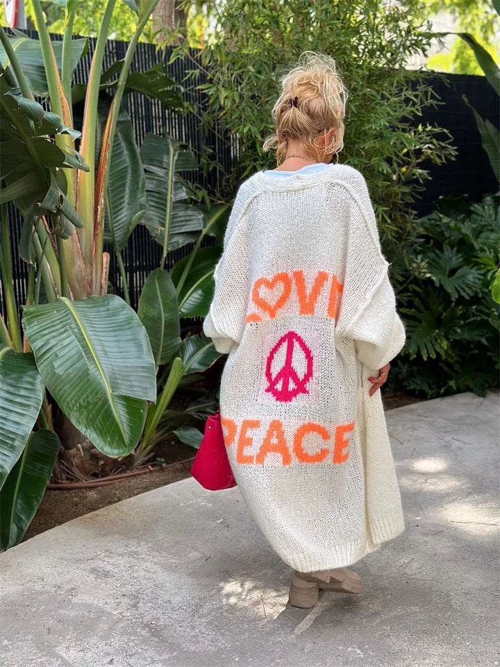 Oversized damecardigan i mykt stoff med unikt "Love & Peace" mønster. Trendy og avslappet lang genser.
