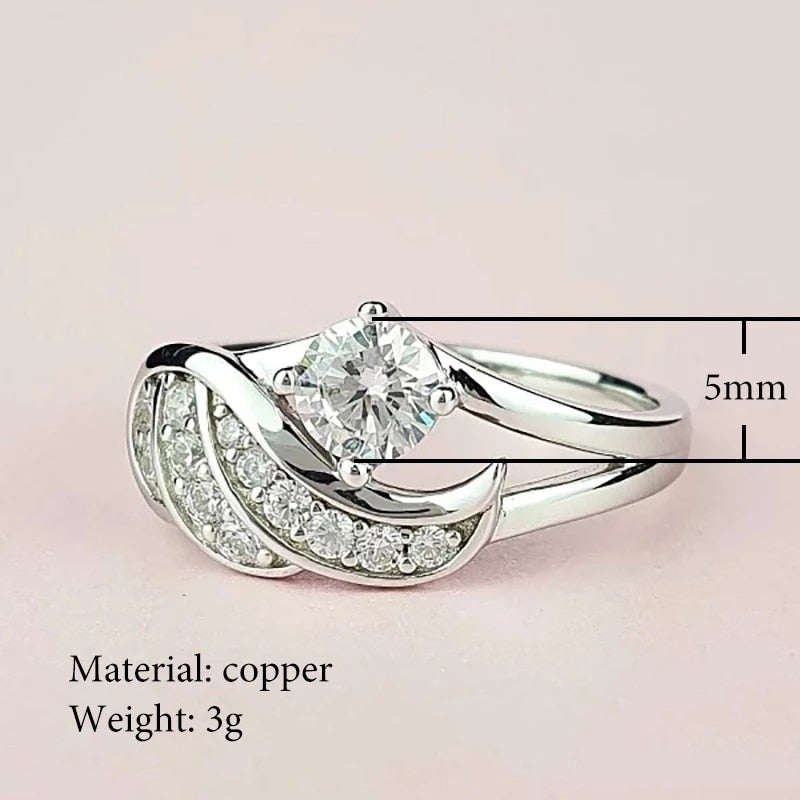 Dame ring med beskyttende englevinge og blendende cubic zirconia. Symboliserer eleganse.