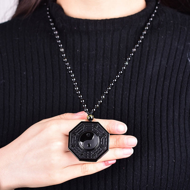 Detaljert nærbilde av obsidian yin yang anheng. Naturstein med blank overflate, balanserende effekt.