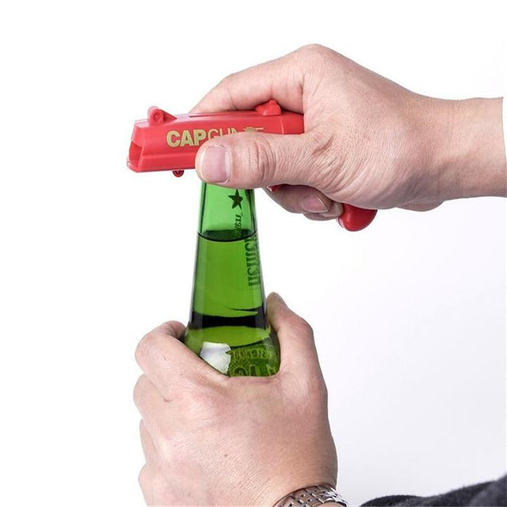 Unik gaveidé: Grå flaskeåpner og korkpistol gadget for festlig stemning.