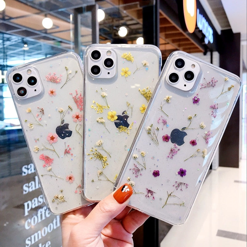 Gjennomsiktig iPhone-deksel med ekte pressede blomster i rosa, lilla og gul. Naturinspirert beskyttelse.