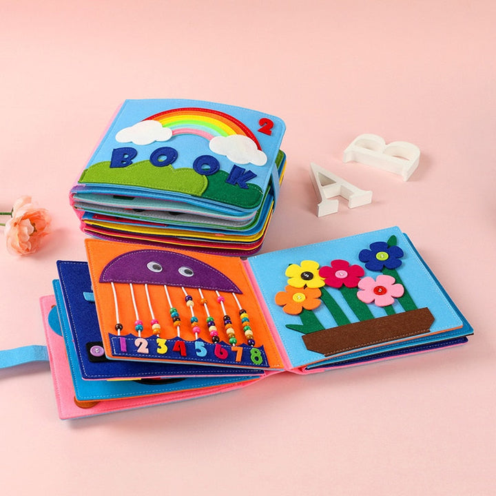 Montessori klutbok for baby, stimulerer læring og finmotorikk med fargerike sider.