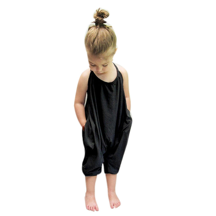 Jente halter jumpsuit i mykt, ensfarget stoff for lek og komfort. Perfekt sommer lekeantrekk for barn.