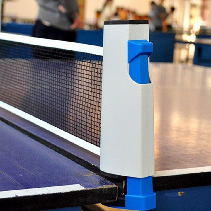 Bordtennissett med detaljer: røde/blå racketer, hvite baller og nett. Klar for rekreasjon og familiehygge.