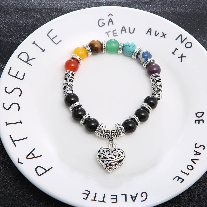 Nærbilde av glatte, polerte chakra steiner i et vakkert armbånd for healing.