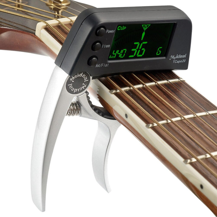 Praktisk gitar capo med innebygd digital tuner for enkel og rask stemming, et must for enhver musiker.