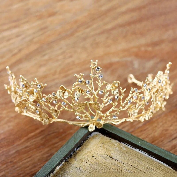 Detaljert bilde av gyllen øyenstikker tiara med barokk design, egnet for fest og spesielle anledninger.