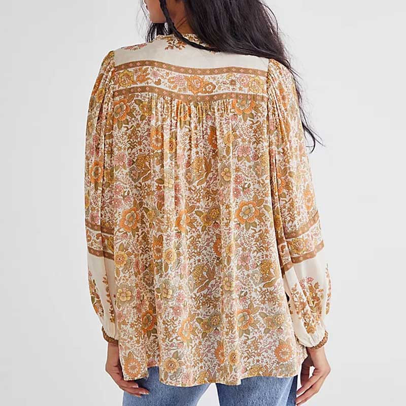 Topas damebluse, inspirert av bohemsk stil, med v-hals og sjarmerende duskdetaljer.