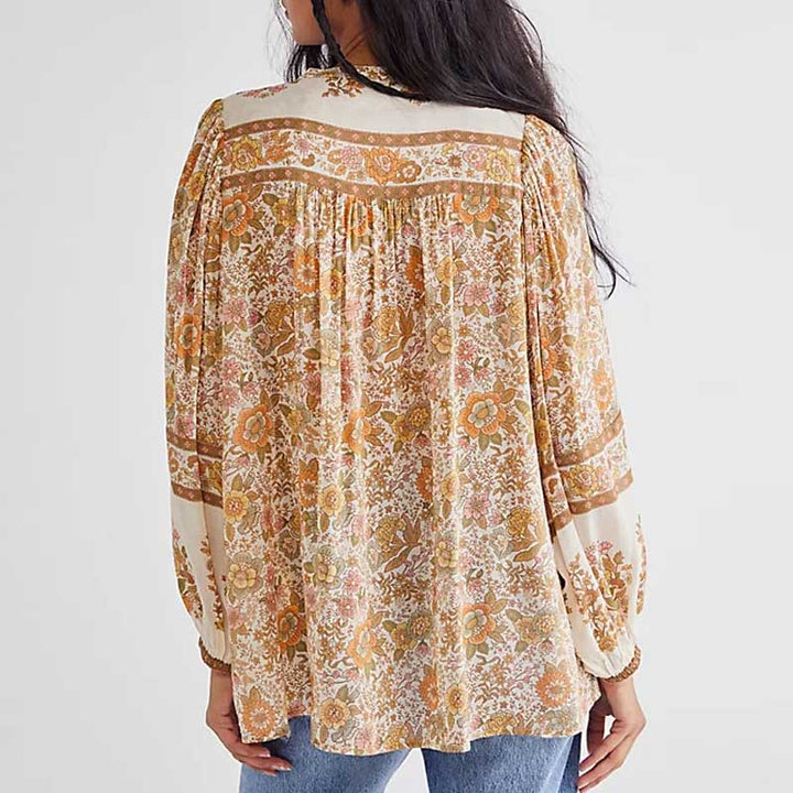 Topas damebluse, inspirert av bohemsk stil, med v-hals og sjarmerende duskdetaljer.