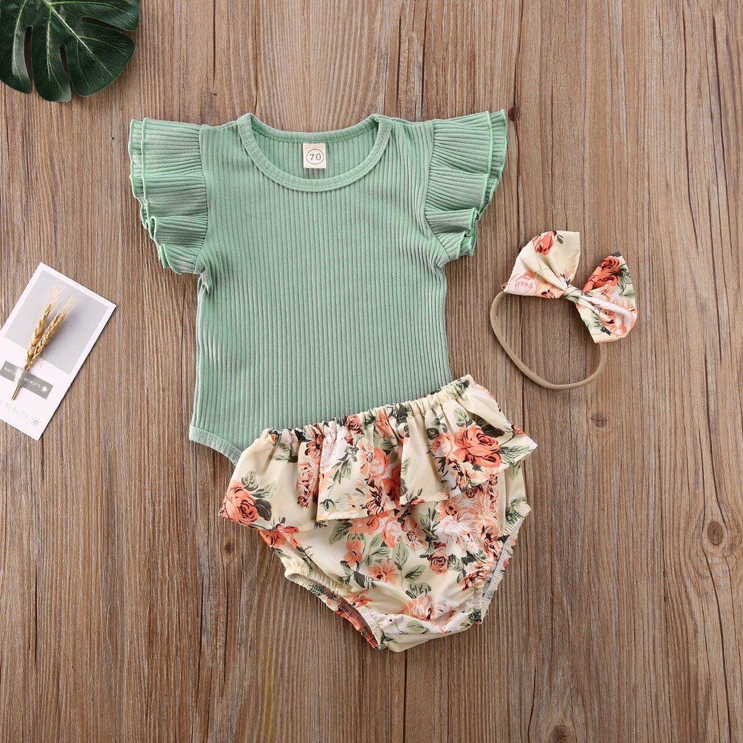 Nært bilde av det detaljerte blomstermønsteret på baby jente shorts settet med volanger.
