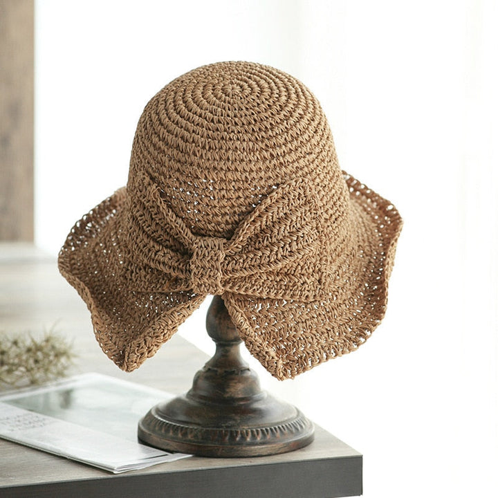 Elegant stråhatt for kvinner med bred brem. Trendy strandhatt for solbeskyttelse og mote om sommeren.