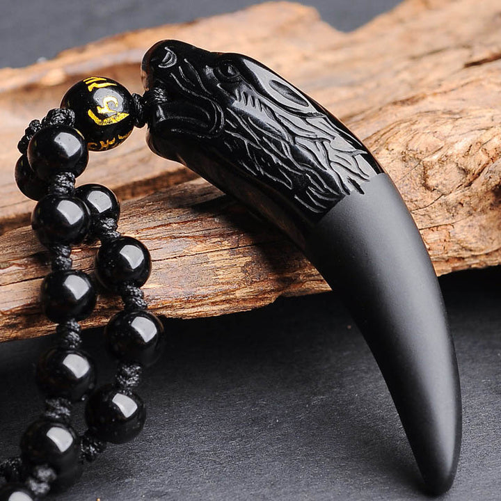 Detaljert obsidian anheng formet som en ulv. Ideelt smykke for beskyttelse og energi.