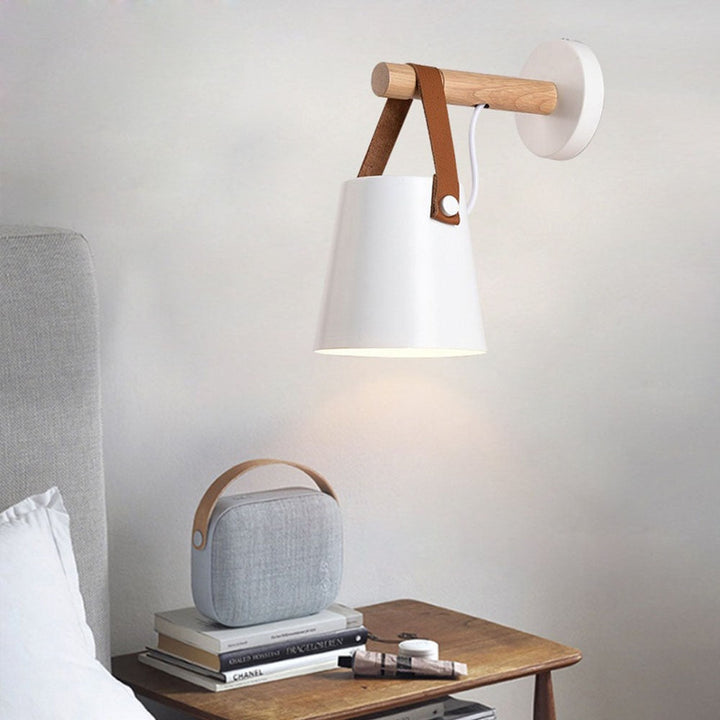 Nærbilde av nordisk trevegglampe med dimbar funksjon, fremhever materialets struktur.