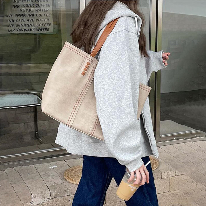 Motebevisst dame med elegant semsket skinnveske. Allsidig totebag og arbeidsveske med stilige kontrastfarger.