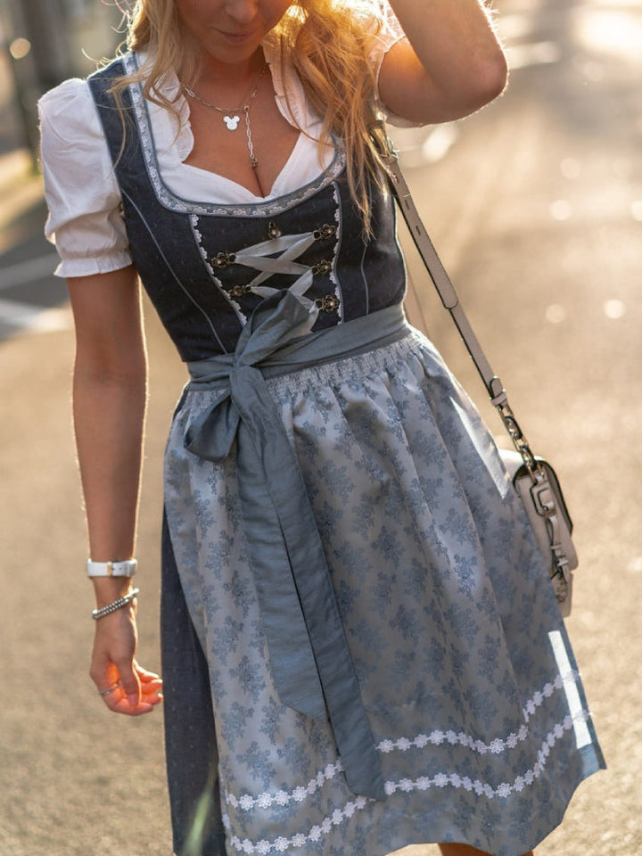 Modell viser elegant, tradisjonell dirndlkjole i blått med forkle, ideell for Oktoberfest og kostyme.