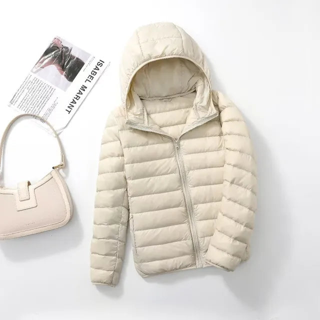Allsidig kvinne dunjakke, lettvekt og quilted, perfekt som reisejakke med hette. Varm og casual.