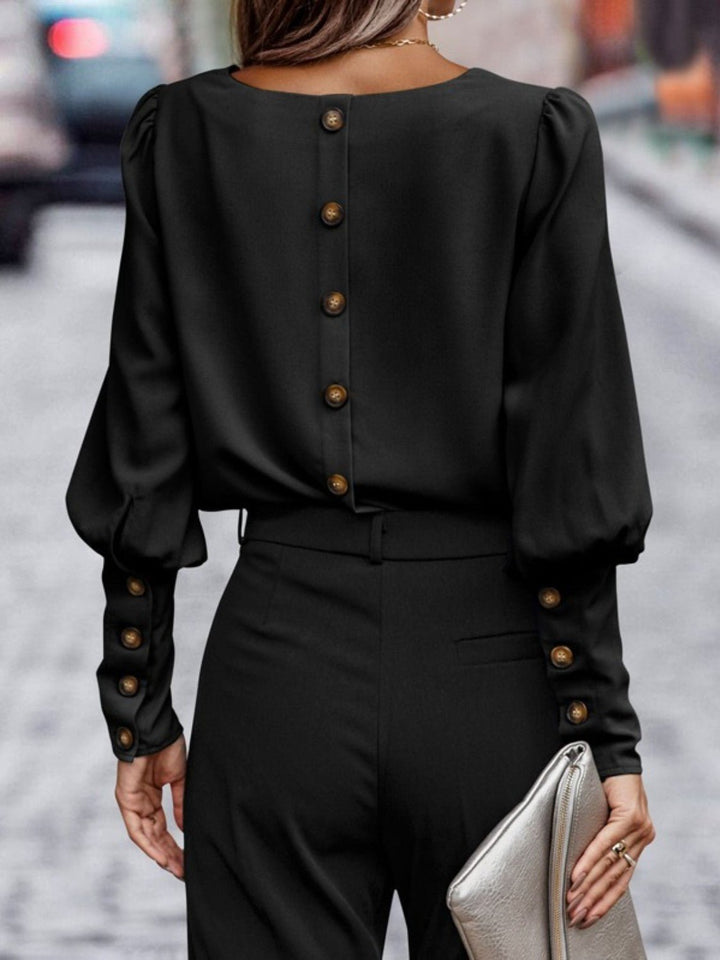Nærbilde av kvinnebluse med rund hals og lykteermer. Viser stoff, snitt og elegant stil.