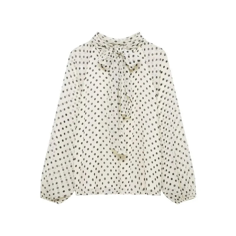 Elegant kvinnebluse med polkaprikker og stilige lanterneermer, perfekt for kontor eller fest.