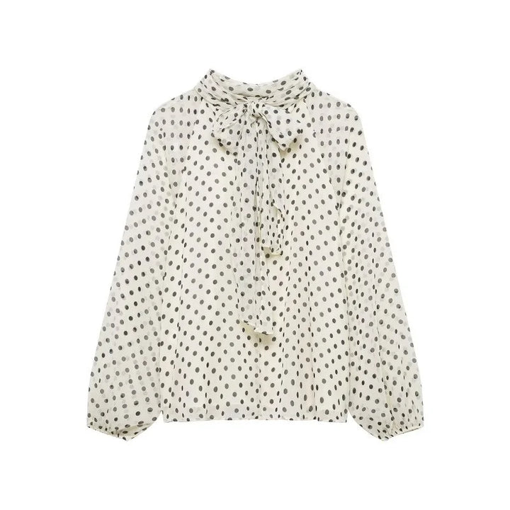 Elegant kvinnebluse med polkaprikker og stilige lanterneermer, perfekt for kontor eller fest.