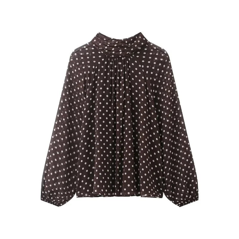 Kvinnebluse med klassiske polkaprikker og unike lanterneermer, ideell for et elegant utseende.
