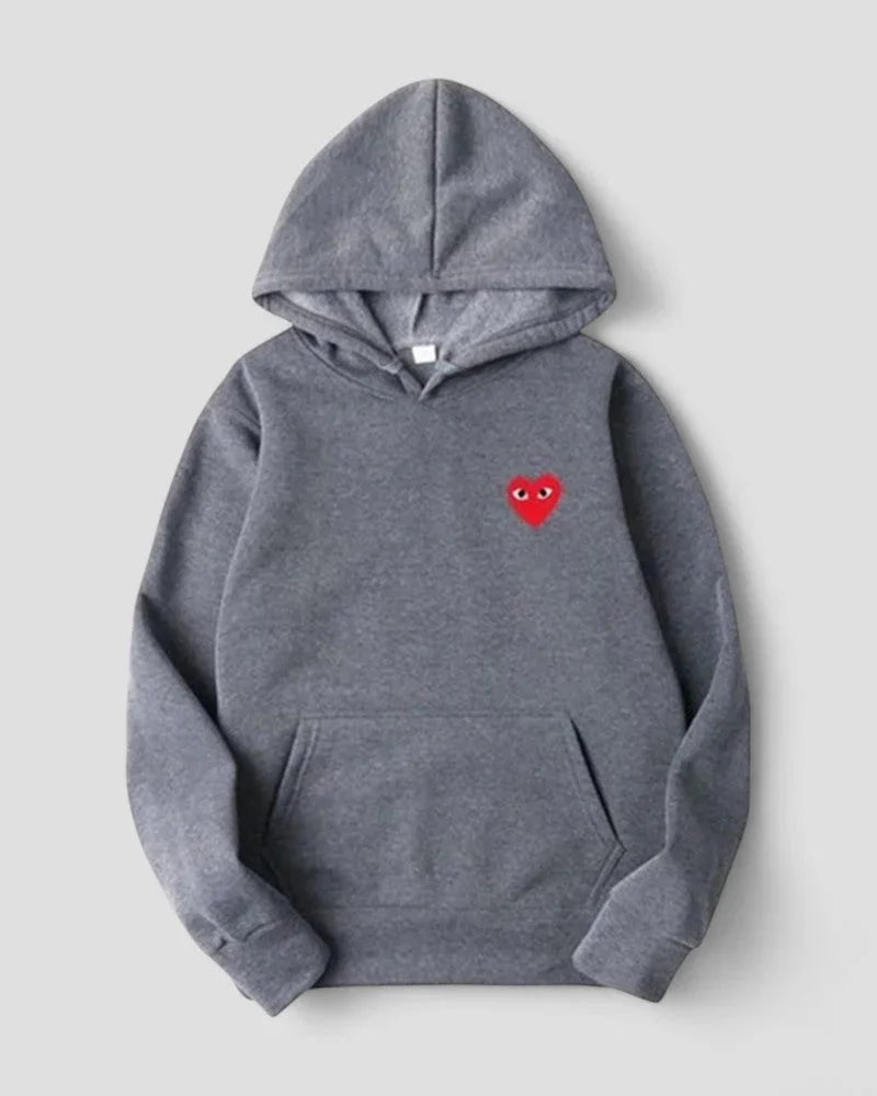 Detaljbilde av stofftekstur på myk kvinnegenser. Broderte hjerter gir et stilfullt preg.