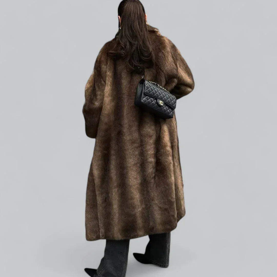 Elegant og varm lang brun vintertrenchcoat for kvinner. En motekåpe som passer perfekt for kalde vinterdager.