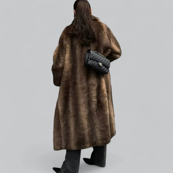 Elegant og varm lang brun vintertrenchcoat for kvinner. En motekåpe som passer perfekt for kalde vinterdager.